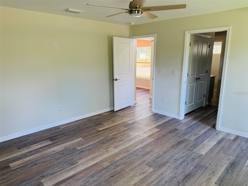 13465 Canyon Swallow Road Weeki Wachee, FL 34614 - Photo 14 of 22 a view of a room with wooden floor closet and windows