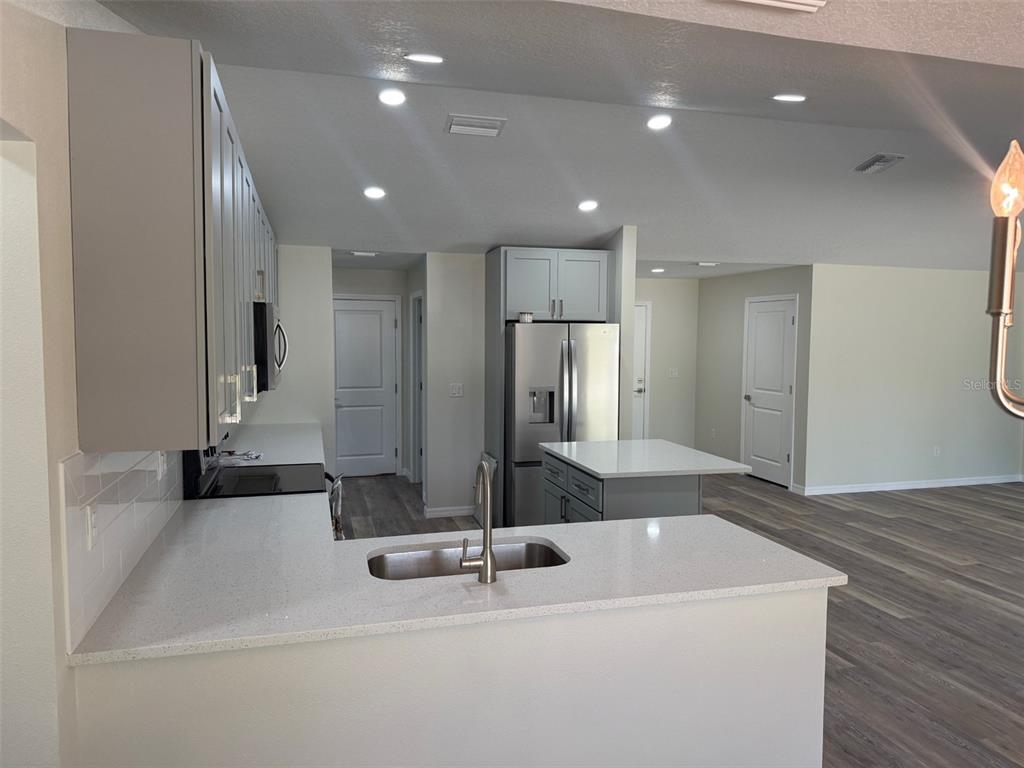 13465 Canyon Swallow Road Weeki Wachee, FL 34614 - Photo 6 of 22 a large kitchen with kitchen island a sink stainless steel appliances and cabinets