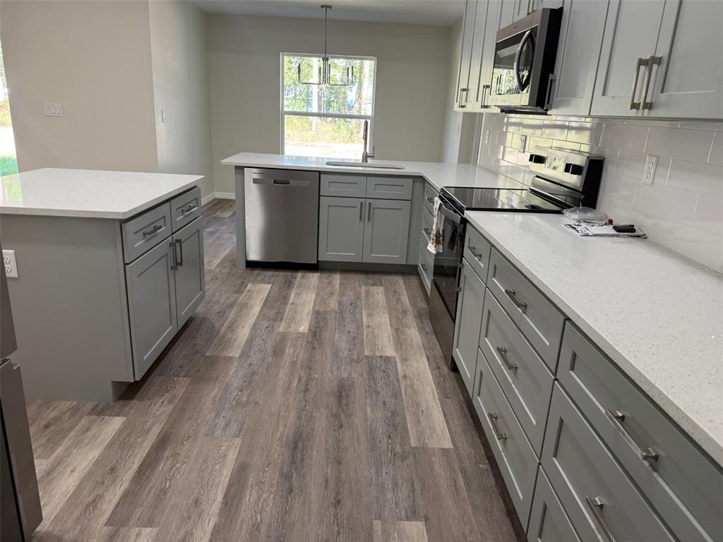 13465 Canyon Swallow Road Weeki Wachee, FL 34614 - Photo 8 of 22 a kitchen with a sink stove and cabinets