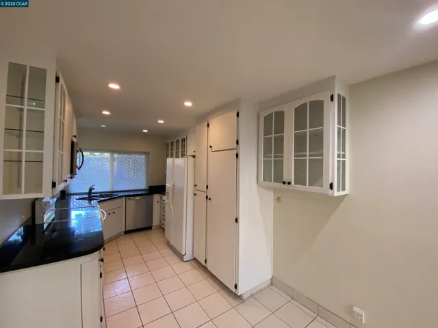 a kitchen with stainless steel appliances kitchen island granite countertop a refrigerator and a stove top oven