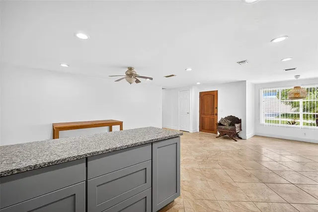a view of wooden floor and a chandelier fan in a room