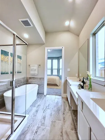 a spacious bathroom with a double vanity sink a large mirror and bathtub