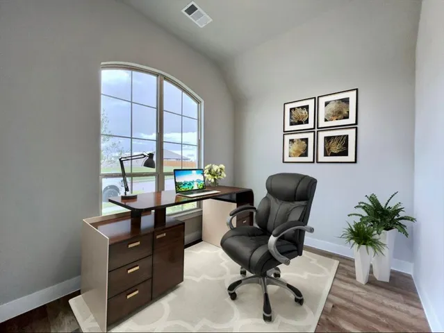 a view of a workspace with furniture and a window
