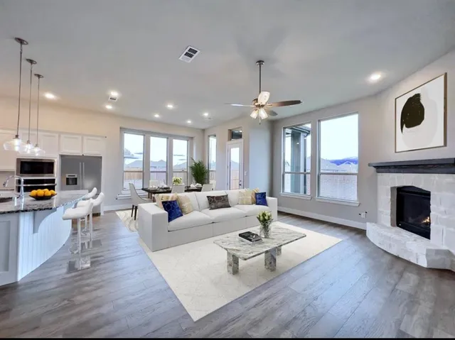 a living room with furniture a fireplace and a kitchen view