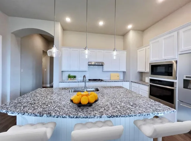 a kitchen with a stove a faucet and chairs