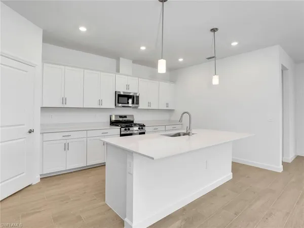 a kitchen with kitchen island a sink stainless steel appliances and cabinets