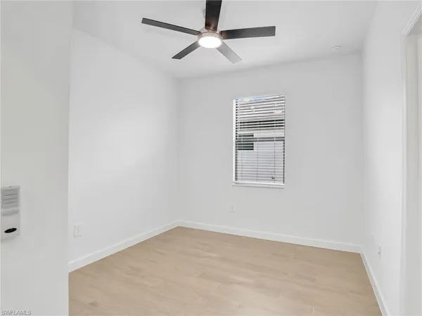 an empty room with closet and windows