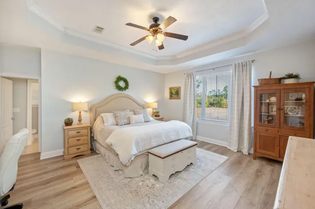 a spacious bedroom with a bed and a chandelier