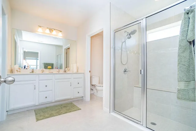 a white toilet sitting next to a white cabinet