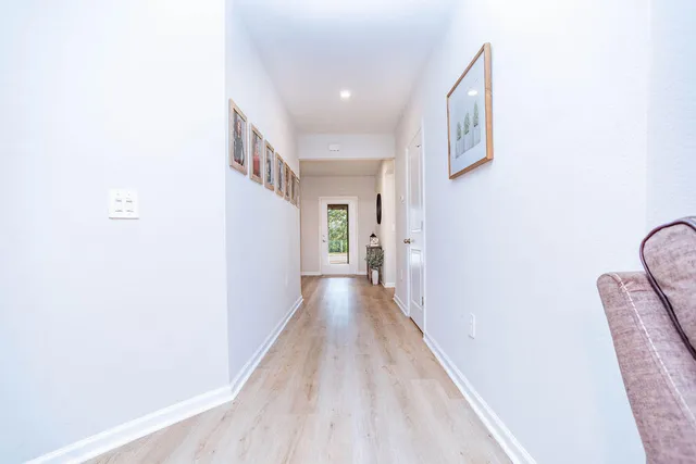 a view of a hallway with wooden floor