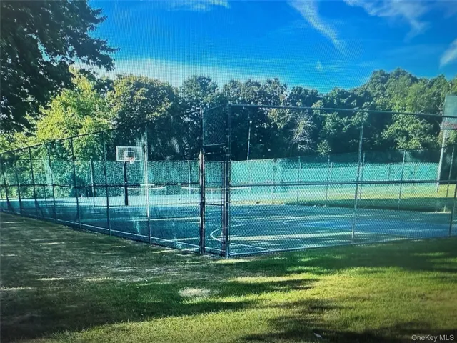 a view of a sign board with yard and green space