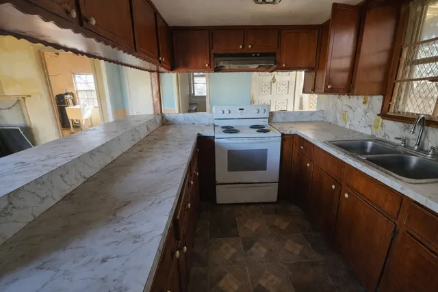 a kitchen with stainless steel appliances granite countertop a sink a stove and a wooden floors
