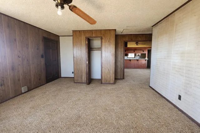 an empty room with a ceiling fan and entryway