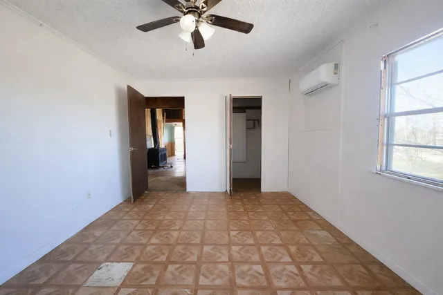 a view of a hallway with a chandelier fan and windows