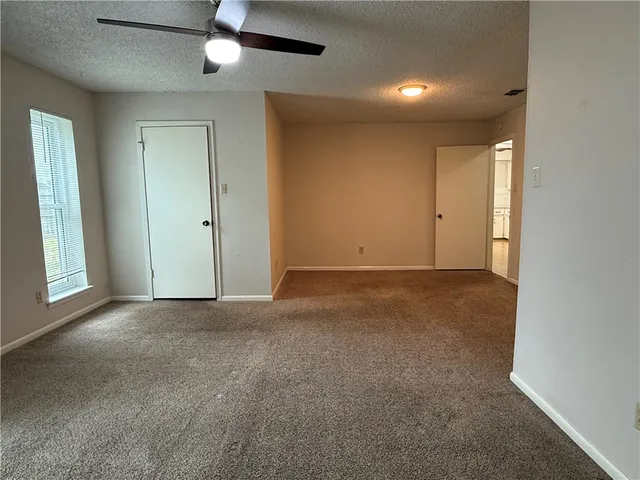 an empty room with a ceiling fan and a window