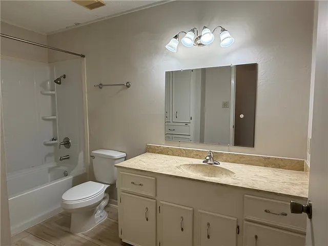 a bathroom with a granite countertop toilet a sink and a bathtub