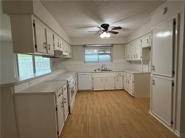 a kitchen with a sink a window stainless steel appliances and cabinets