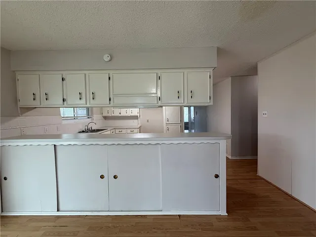 a kitchen with stainless steel appliances granite countertop a sink a stove a refrigerator and cabinets