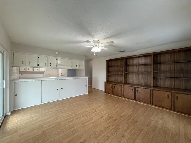 a view of a kitchen with wooden floor and cabinets