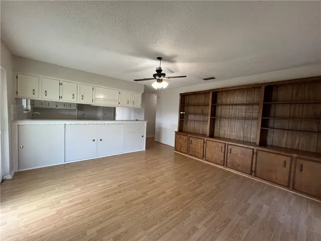 a view of a kitchen with wooden cabinet and a stove top oven