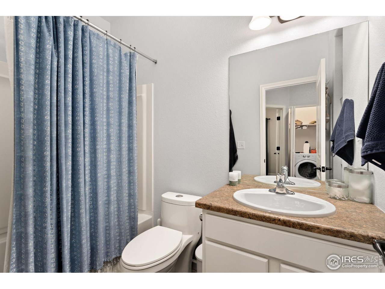 1833 Sunset Circle Milliken, CO 80543 - Photo 12 of 21 a bathroom with a granite countertop sink a toilet a mirror and shower curtain