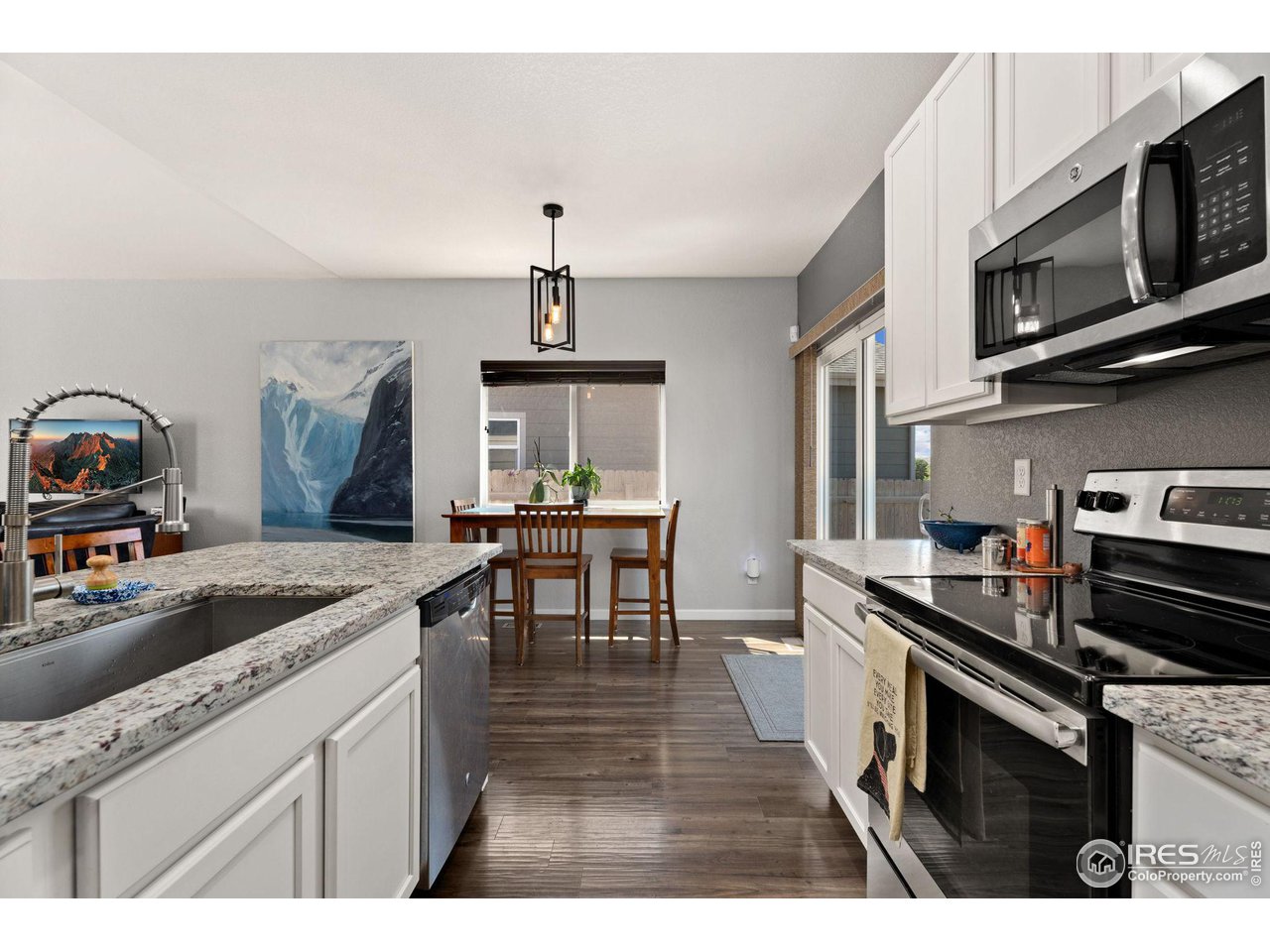 1833 Sunset Circle Milliken, CO 80543 - Photo 6 of 21 a kitchen with stainless steel appliances granite countertop a sink stove and microwave