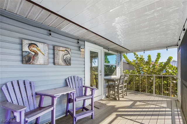 a view of a patio with table and chairs potted plants with wooden floor and fence