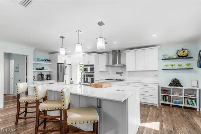 a kitchen with cabinets a counter and chairs in it