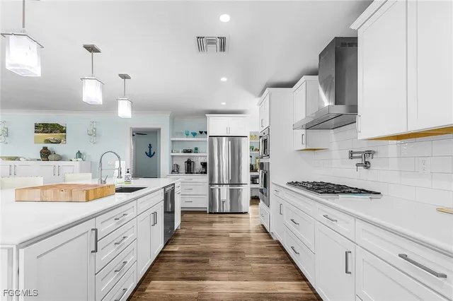 a large kitchen with stainless steel appliances granite countertop a sink stove and refrigerator