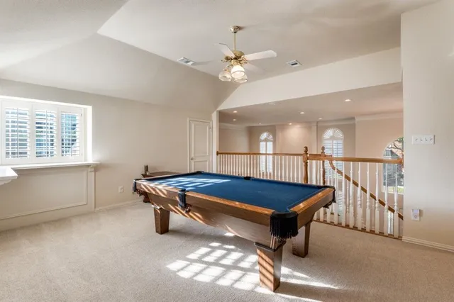 a room with pool table and windows