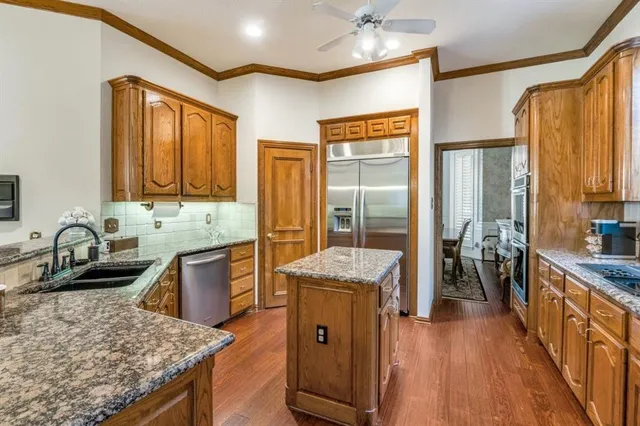a kitchen with stainless steel appliances granite countertop a sink stove and refrigerator