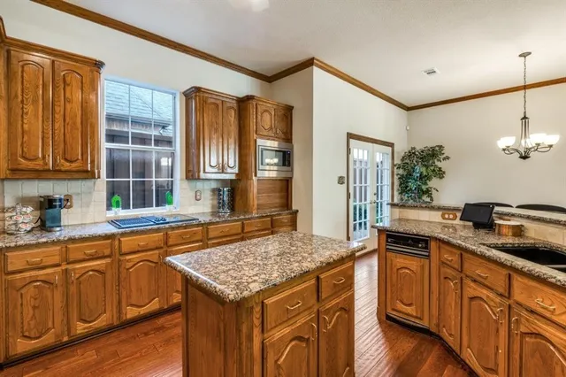 a kitchen with granite countertop center island wooden cabinets and stainless steel appliances