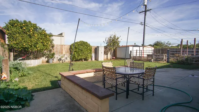 a view of a patio with a table chairs and a small yard