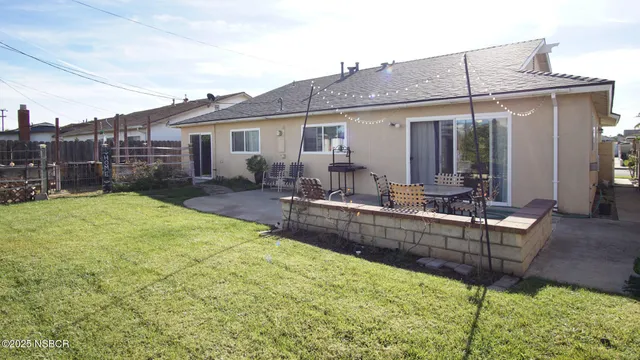 a view of a house with backyard and sitting area
