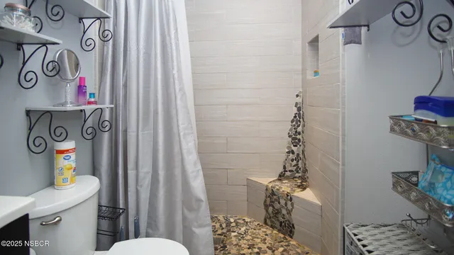 a bathroom with a toilet and shower curtain