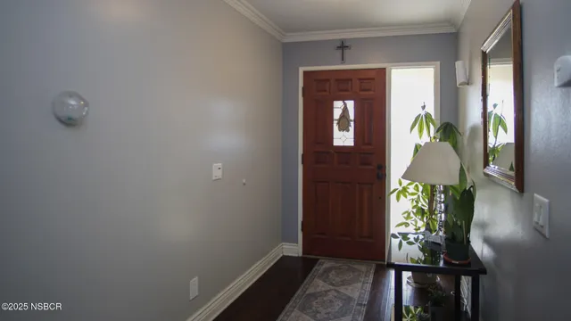 a hallway with front door wooden floor and windows