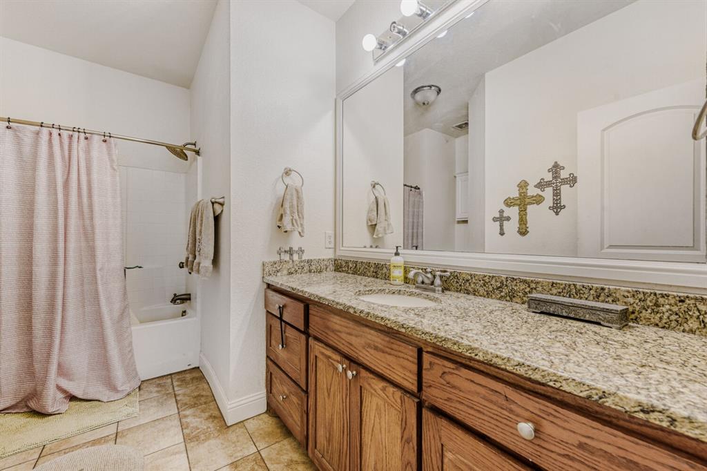 6525 Greenway Road Fort Worth, TX 76116 - Photo 11 of 29 a bathroom with a granite countertop sink and a mirror