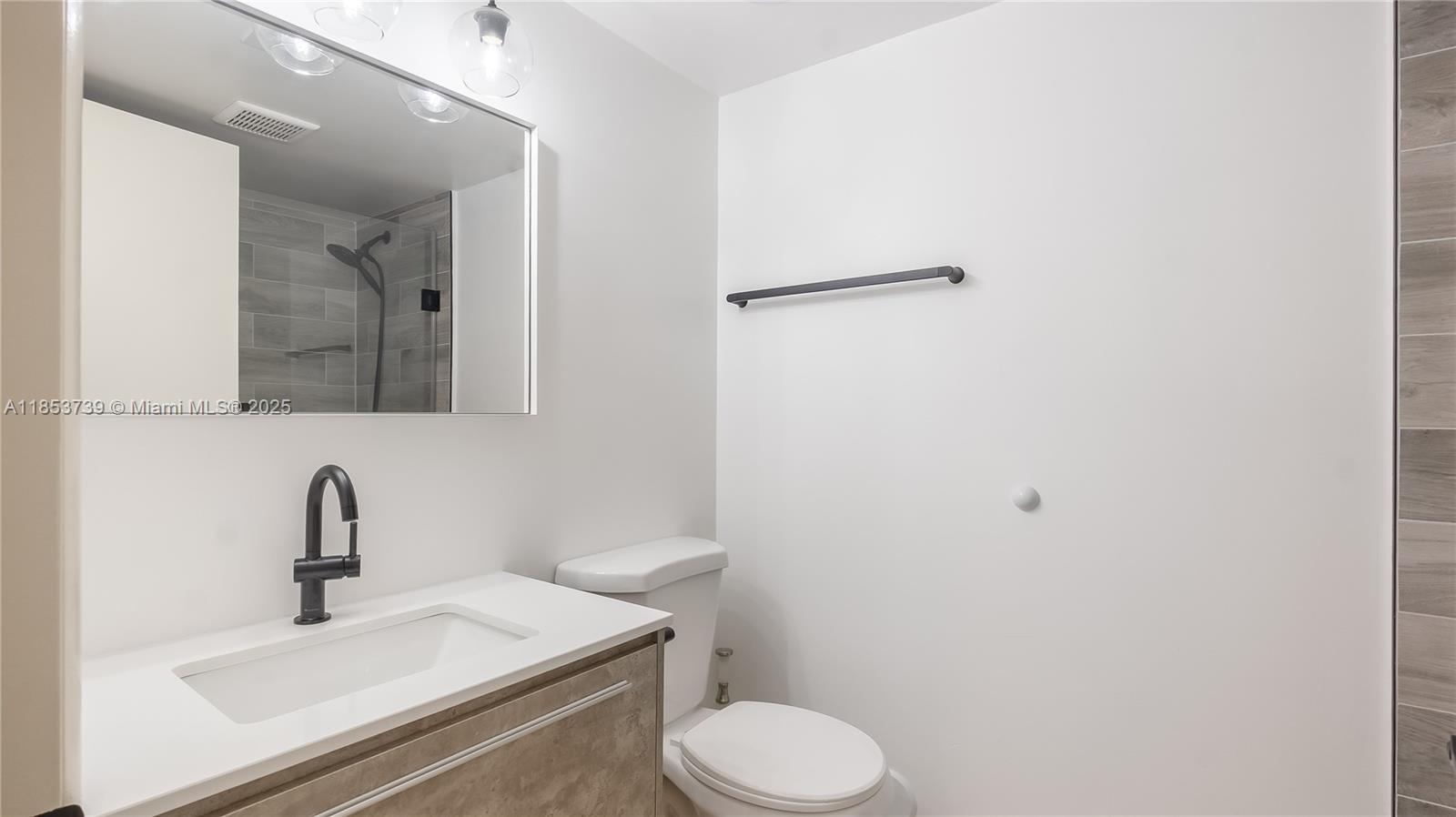 5686 Rock Island Road, Unit 106 Tamarac, FL 33319 - Photo 21 of 34 a bathroom with a sink toilet and a mirror