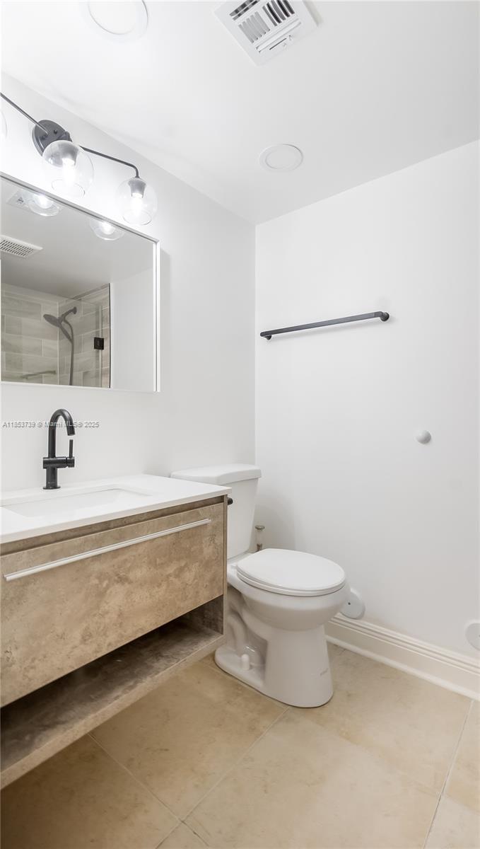 5686 Rock Island Road, Unit 106 Tamarac, FL 33319 - Photo 22 of 34 a bathroom with a sink a toilet and a mirror
