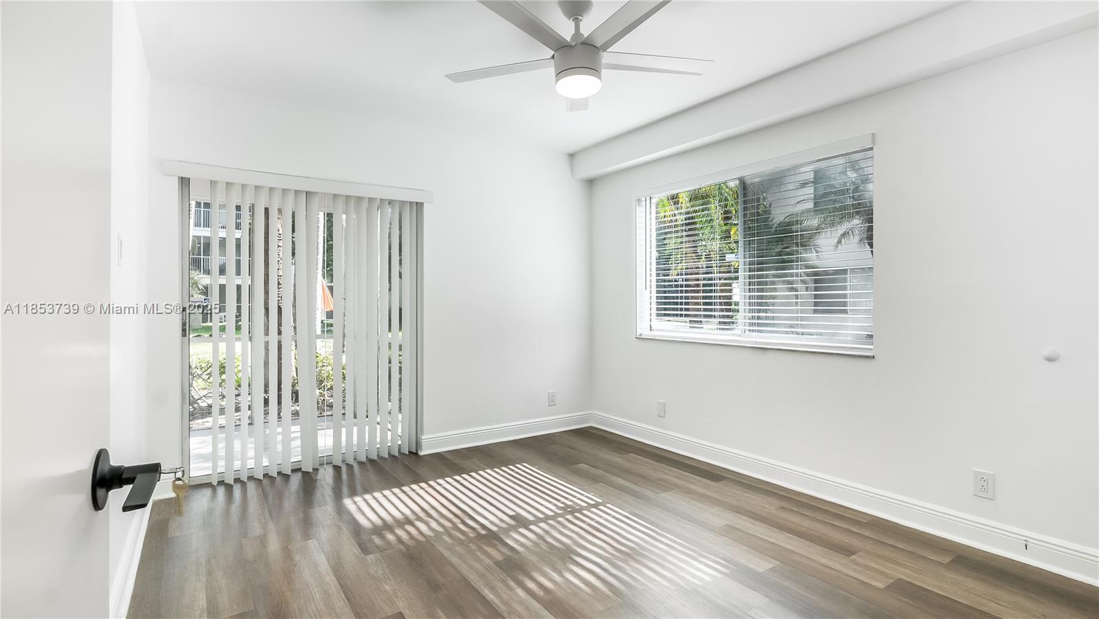 5686 Rock Island Road, Unit 106 Tamarac, FL 33319 - Photo 24 of 34 wooden floor in an empty room with a window