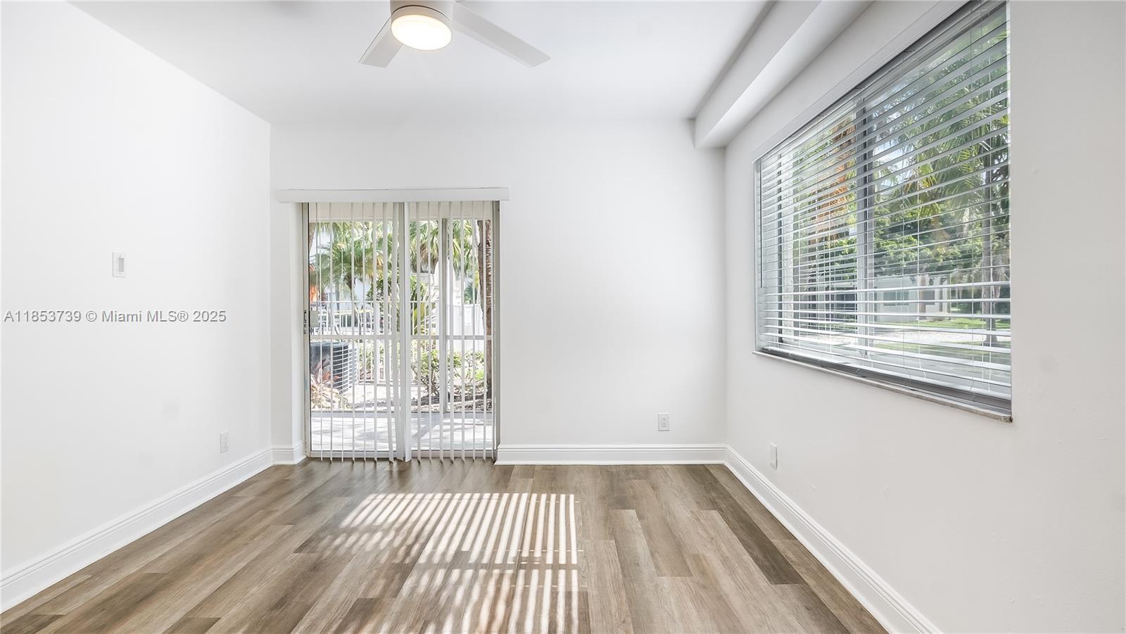 5686 Rock Island Road, Unit 106 Tamarac, FL 33319 - Photo 25 of 34 a view of an empty room with wooden floor and a window