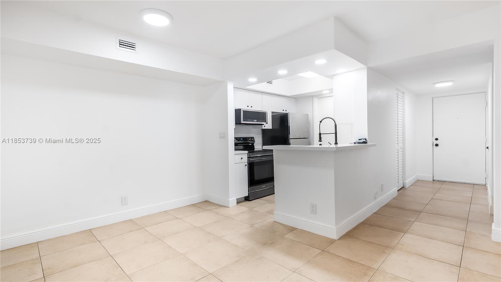 5686 Rock Island Road, Unit 106 Tamarac, FL 33319 - Photo 3 of 34 a kitchen with stainless steel appliances kitchen island granite countertop a refrigerator and a sink