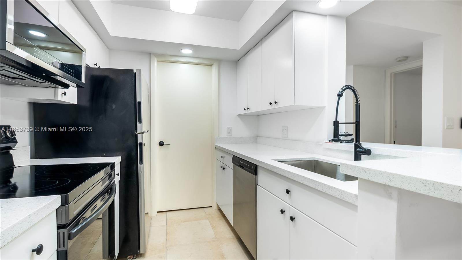 5686 Rock Island Road, Unit 106 Tamarac, FL 33319 - Photo 5 of 34 a kitchen with a sink and a refrigerator