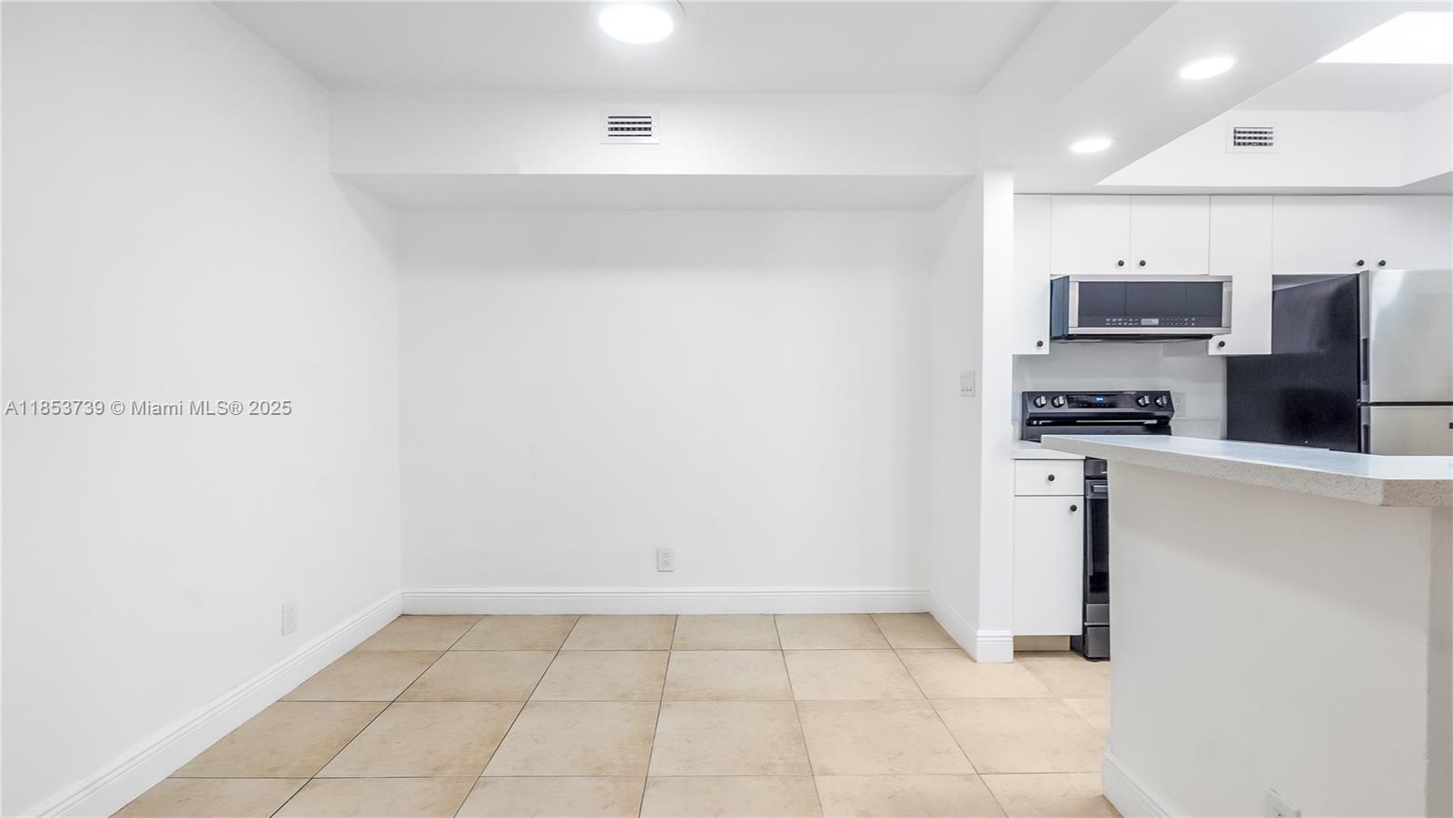 5686 Rock Island Road, Unit 106 Tamarac, FL 33319 - Photo 6 of 34 a view of kitchen with refrigerator and microwave