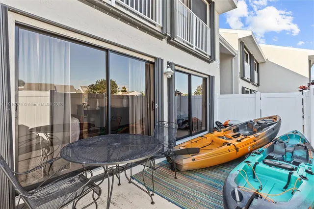 a backyard of a house with barbeque oven table and chairs
