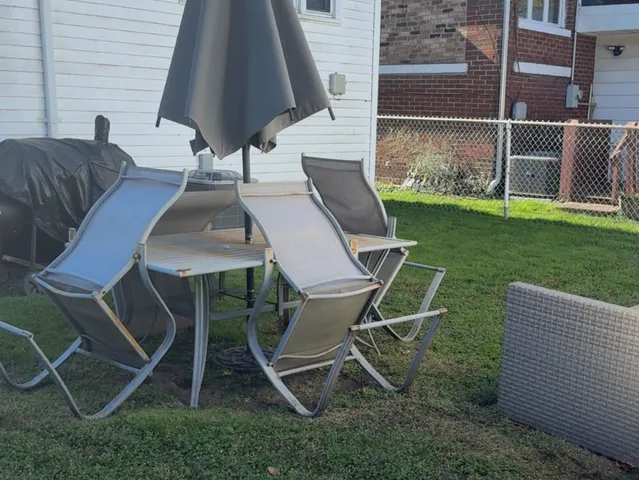 a view of backyard with seating space and wooden fence