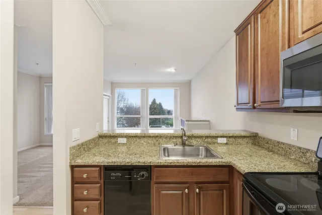 a kitchen with granite countertop a sink and a white cabinets