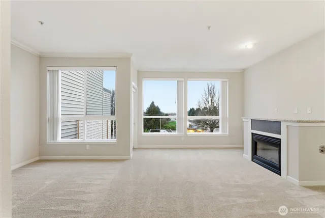 an empty room with windows fire place and a fireplace