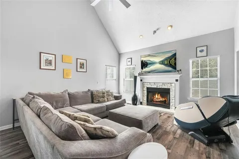 a kitchen with granite countertop stainless steel appliances a stove oven a sink dishwasher and white cabinets with wooden floor