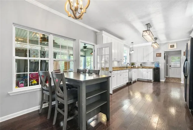 a kitchen with granite countertop white cabinets and white appliances